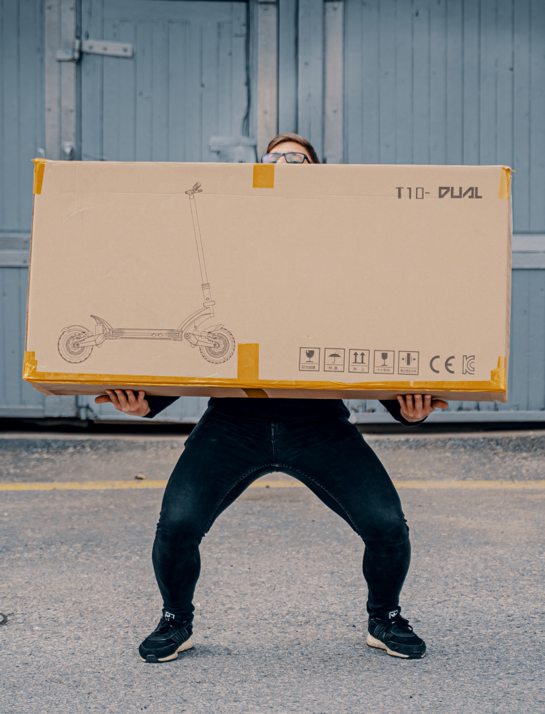 Guy holding a scooter in package shipping delivery