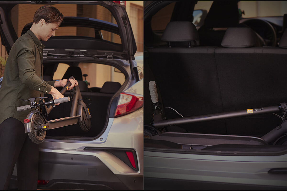 Electric scooter Xiaomi S1 folded in trunk Image of a man putting a folded electric scooter Xiaomi S1 in the car trunk.