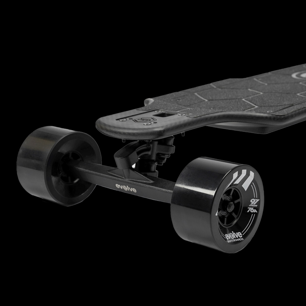 Front left close-up of Evolve Carbon All Terrain electric skateboard showing all-terrain wheels and carbon deck
