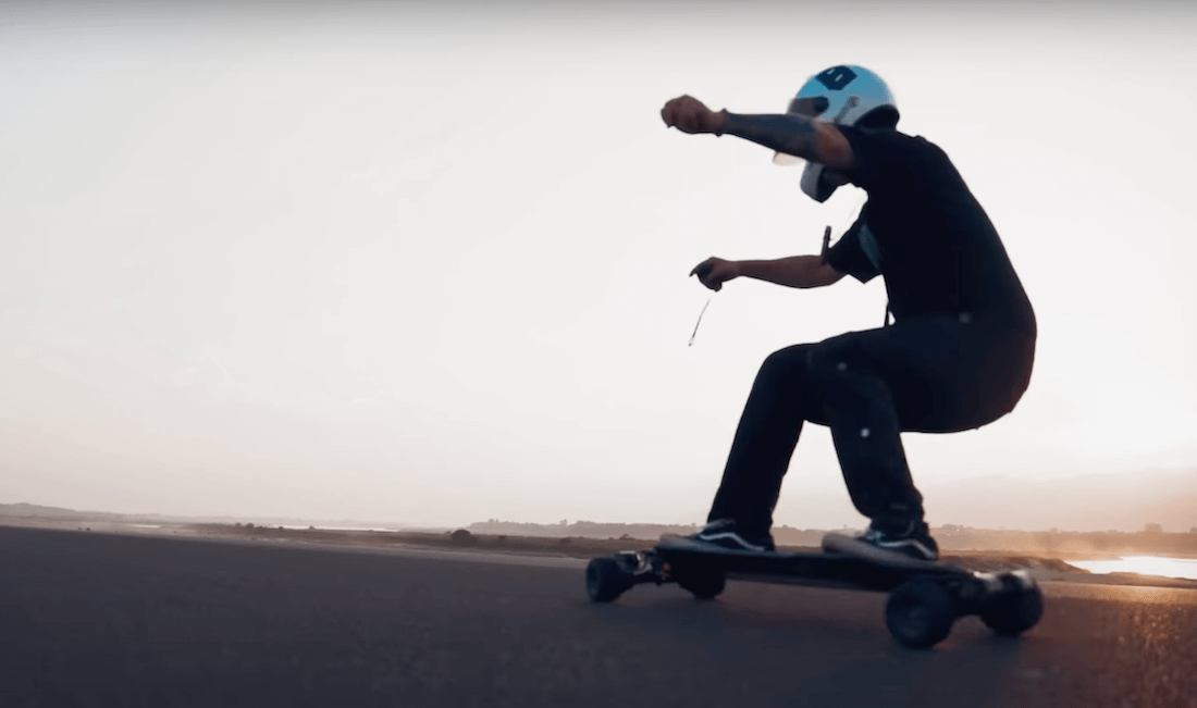 Image of a man riding electric skateboard exway atlas carbon 4wd on asphalt 2.