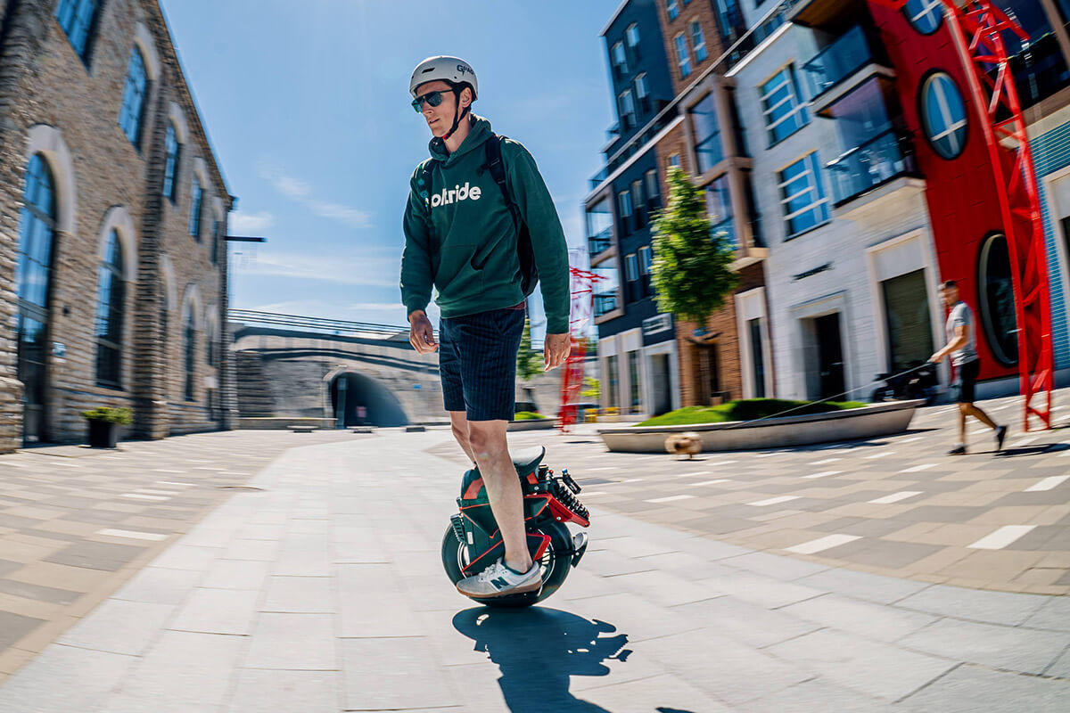 Rider gliding on Kingsong KS S22 Pro+ electric unicycle on a sunny city day with motion blur effect
