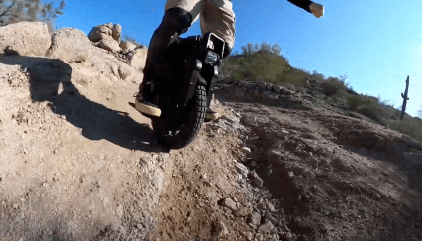 Veteran Sherman S electric unicycle climbing a rocky uphill trail, showcasing its torque and off-road capabilities.