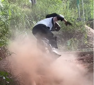 Rider falling off the Veteran Sherman S electric unicycle on a dusty trail, highlighting the need for off-road safety gear.