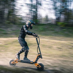Man riding the Inmotion RS electric scooter offroad wearing protectives and a full face helmet.