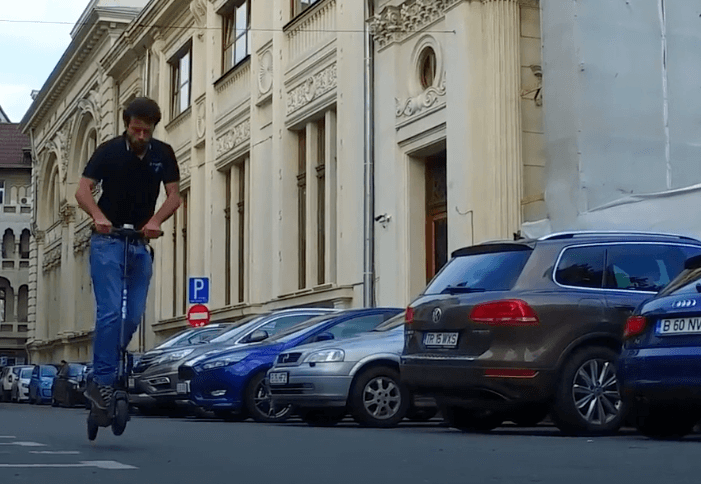 Man jumping with E-TWOW S2 Booster Plus electric scooter in the city, demonstrating agility and performance.