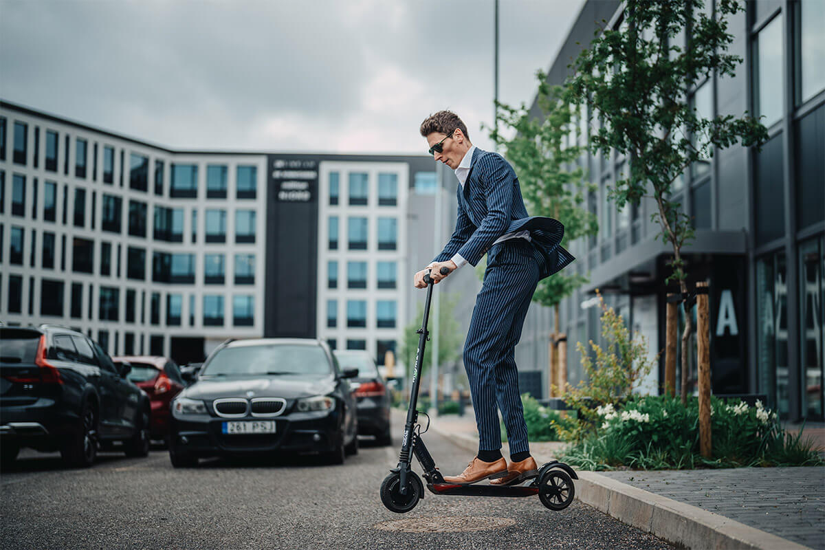 Man mid-jump with E-TWOW S2 Booster V electric scooter, emphasizing agility and lifestyle appeal.