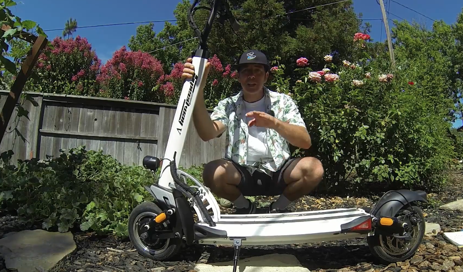 Electric scooter Speedway 5 video thumbnail where a man is sitting behind the scooter in theyard.