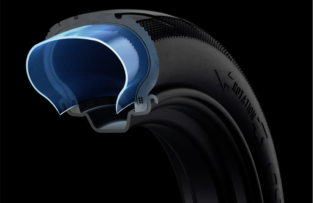 Cross-section view of the Segway-Ninebot E2 Pro E electric scooter tire showing its internal layered structure, including the reinforced outer tread and inner cushioning layer highlighted in blue, demonstrating durability and puncture resistance.