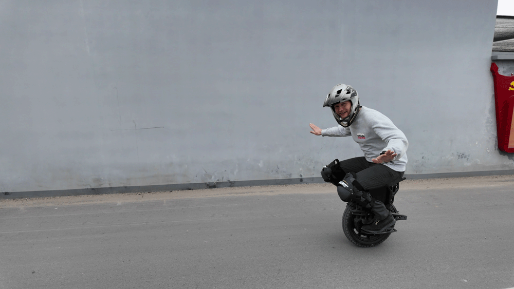 Man balancing on the Veteran Lynx electric unicycle wearing a helmet and protective gear.
