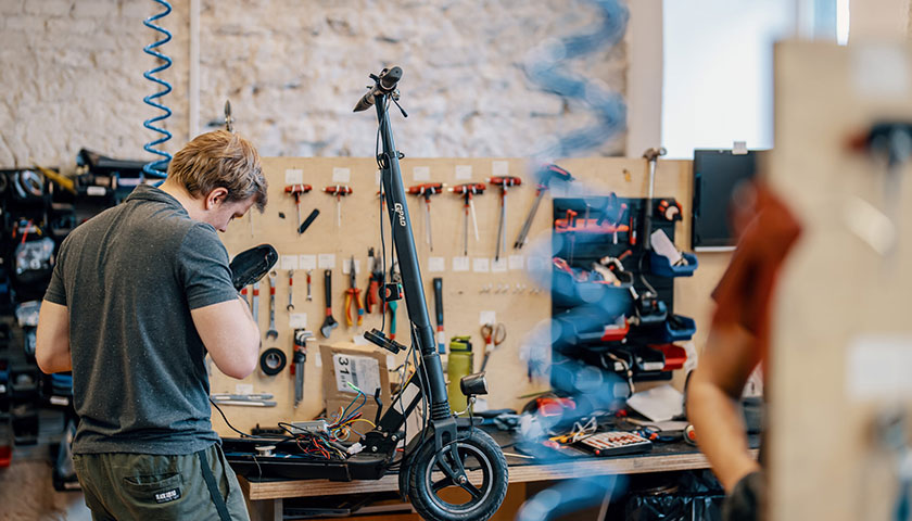 A banner showing a Voltride technician working on an electric kickscooter
