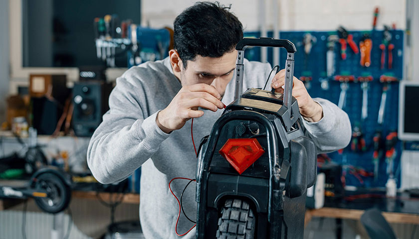 A banner showing a Voltride technician working on an electric unicycle