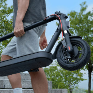 Mies kantaa taitettua Xiaomi-sähköpotkulautaa ulkoportaita pitkin aurinkoisena päivänä