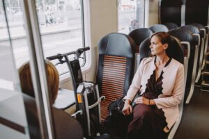 Woman sitting next to the Stigo electric bike on the train.