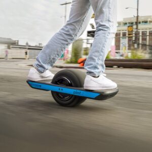 Lähikuva miehestä ajamassa Onewheel Pint X -sähköyksipyörällä kaupunkikadulla