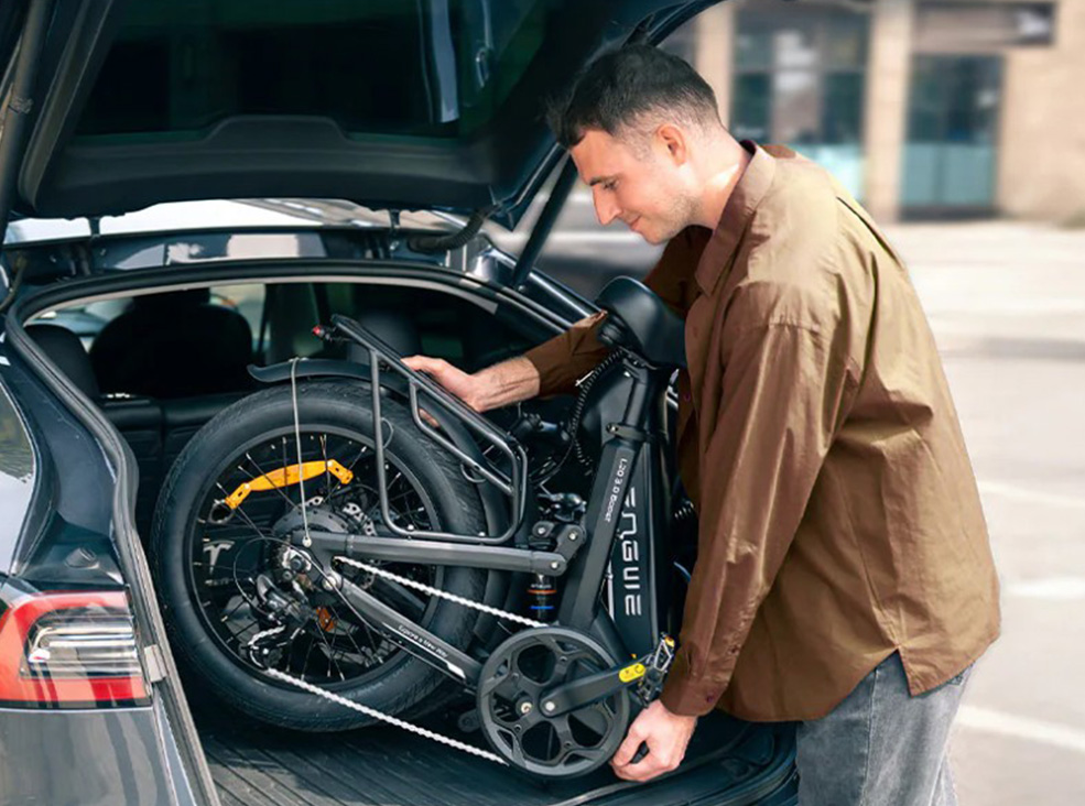 Man loading the Engwe L20 3.0 Boost electric bicycle into a car's trunk demonstrating the bike's foldability.