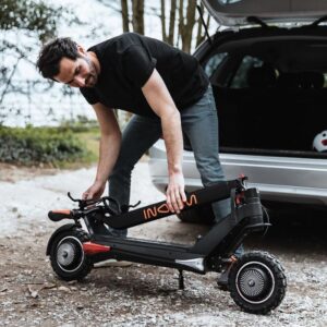 Mees paneb Inokim OXO elektritõukeratta kokku ja asetab selle auto pagasiruumi.