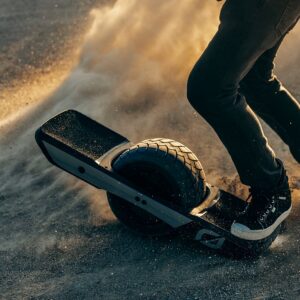 Mies ajamassa Onewheel GT Treaded -sähköyksipyörällä maastossa