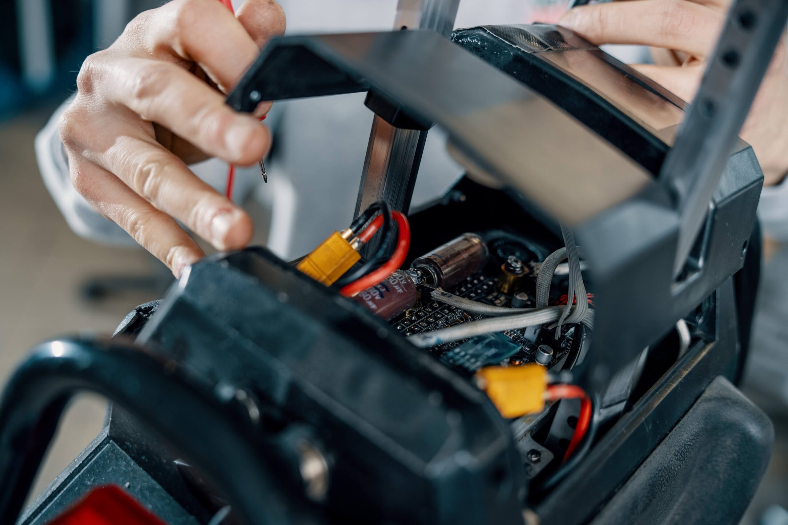 Electric unicycle maintenance blog image 3 Close-up of a technician working on the internal wiring and components of an electric unicycle