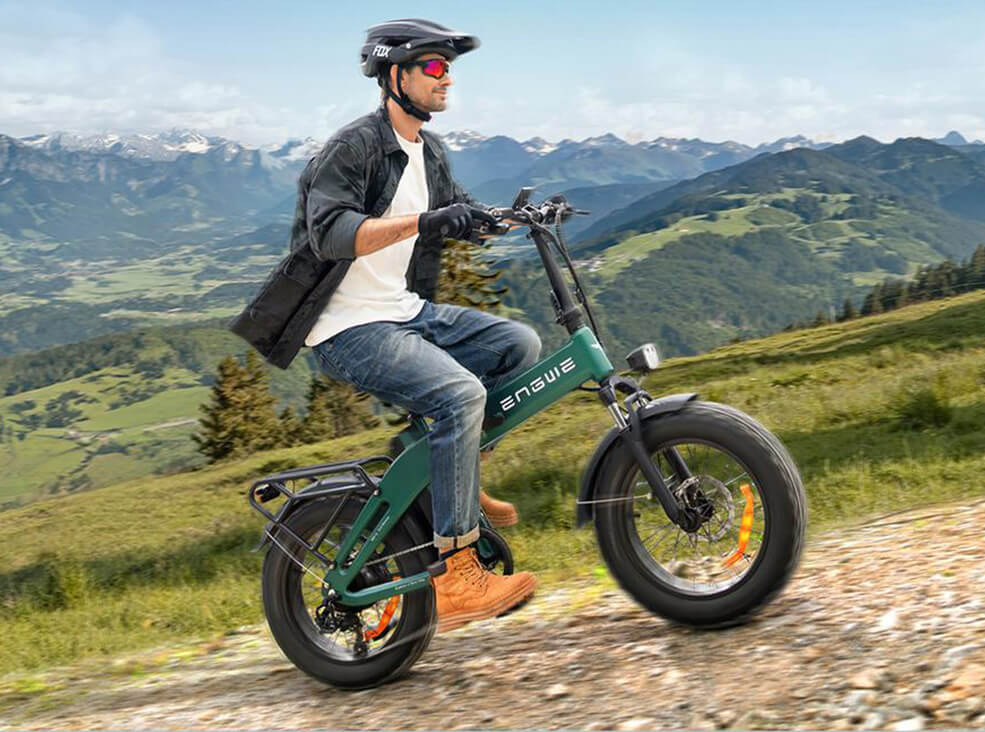 Rider wearing a helmet cycling the Engwe EP-2 3.0 Boost folding electric bike along a mountain trail, showcasing its all-terrain performance and scenic outdoor riding capability.