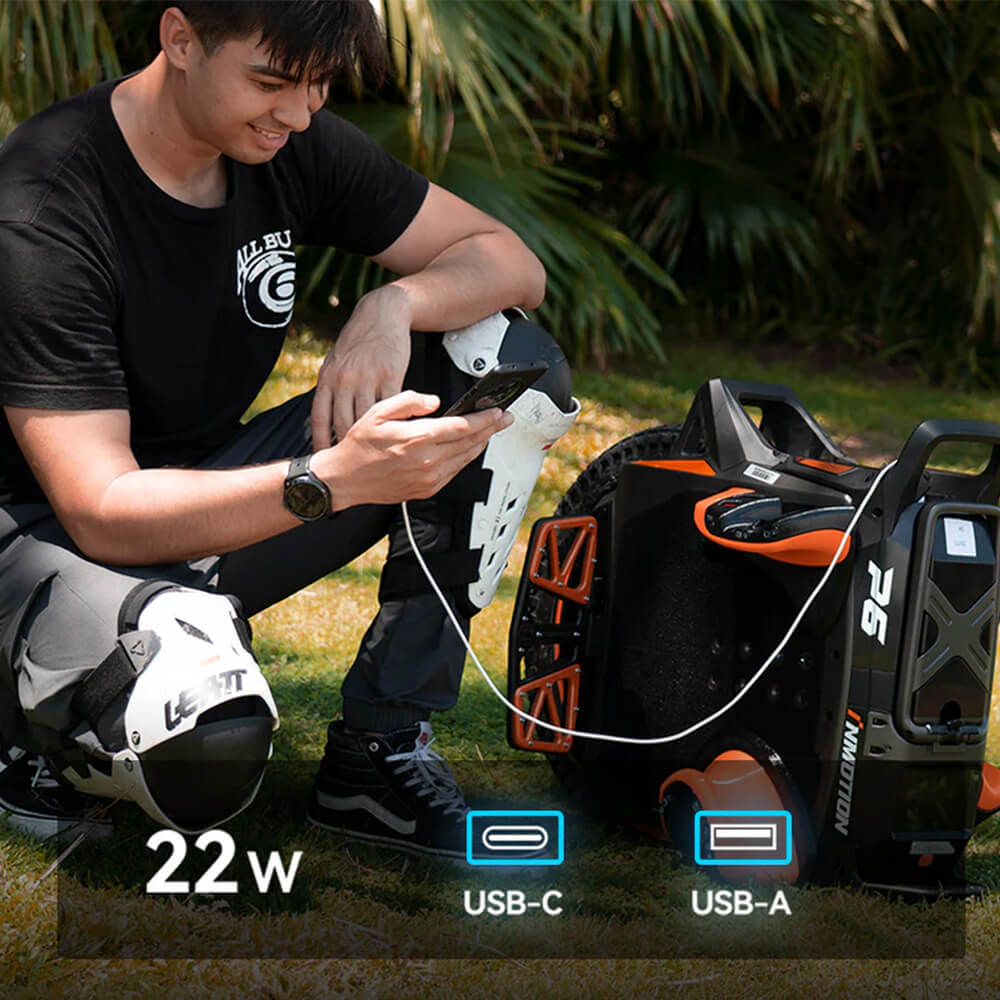 Rider charging a smartphone from the InMotion P6 electric unicycle using the built-in 22W USB-C and USB-A charging ports while wearing protective riding gear outdoors.