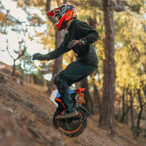 InMotion V14 Pro lifestyle 2 Side view of a rider wearing a full-face helmet and protective gear descending a steep forest trail on an InMotion V14 Pro electric unicycle, demonstrating off-road stability and suspension performance.