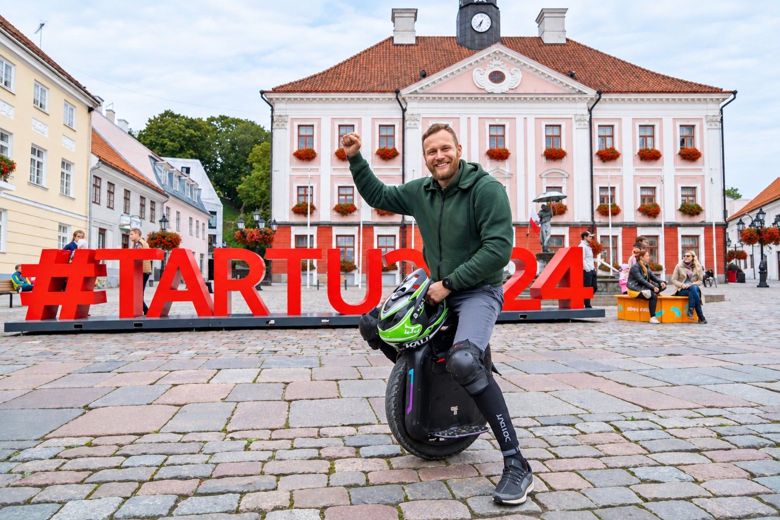 Mart posing infront of Tartu2024 sign after riding on a electric unicycle Gotway Monster Pro from Tallinn to Tartu.