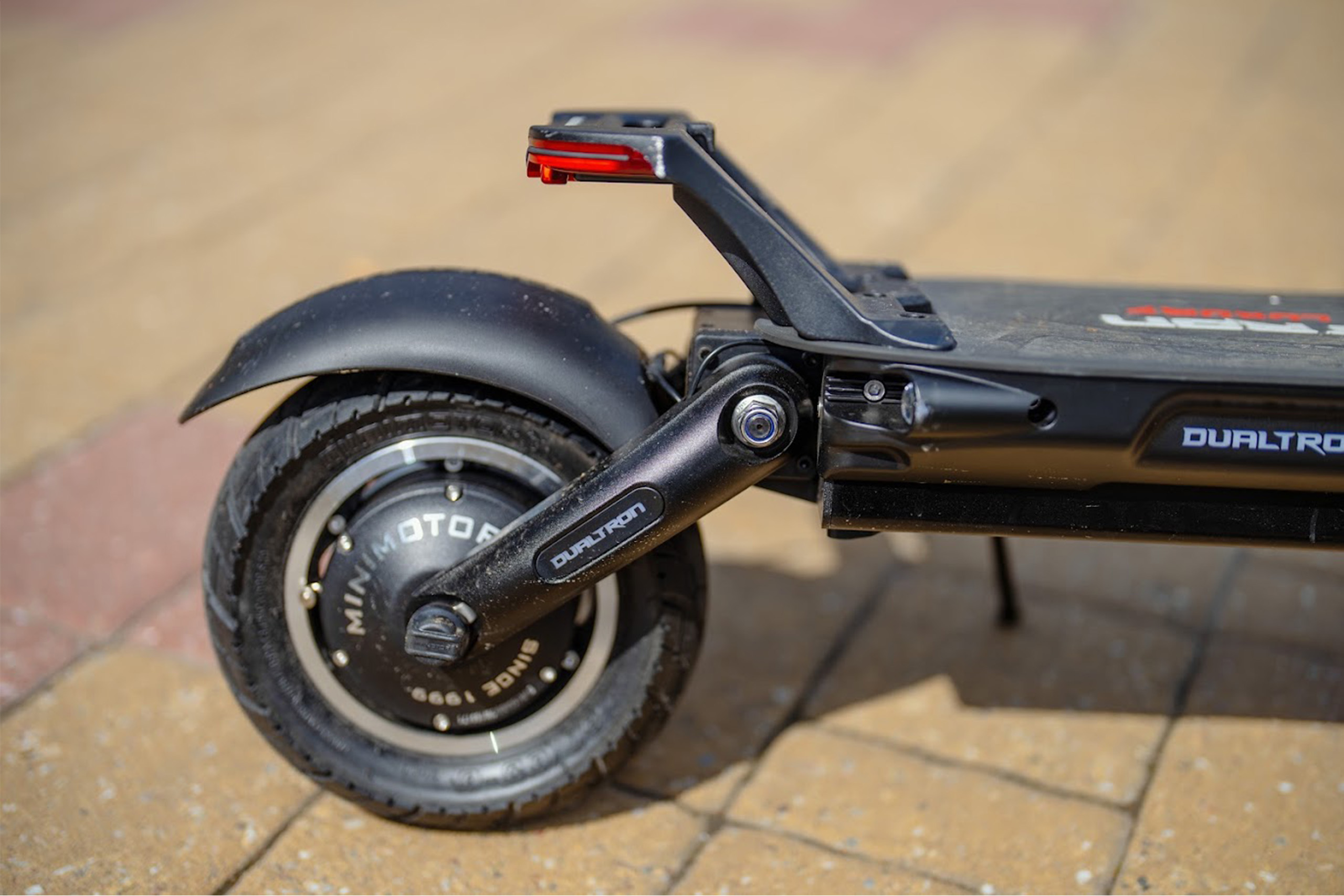 Electric scooter range close up blog image Close-up of a Dualtron electric scooter rear wheel, motor, suspension, mudguard and footrest.